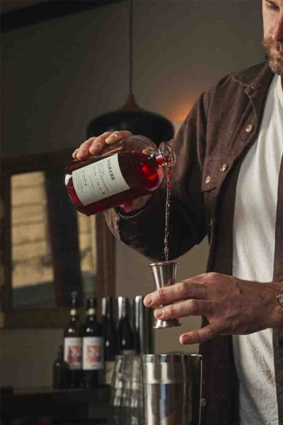 Photo d’un homme qui est en train de doser la quantité d'alcool de merise pour le cocktail